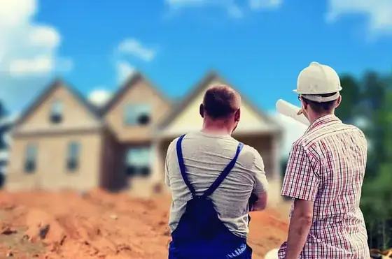 Réunion de chantier entre maître d’ouvrage et maître d’œuvre autour de plans.